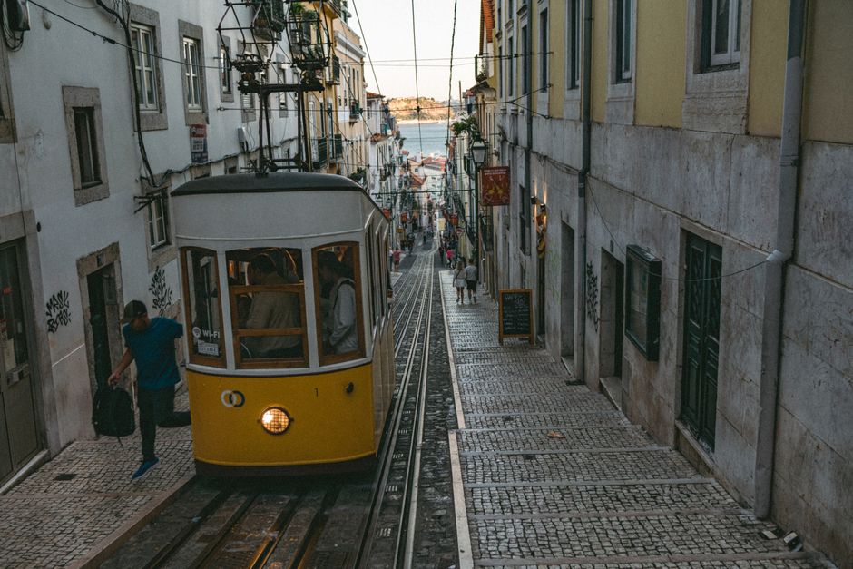 Zabytkowy tramwaj na brukowanej ulicy w Lizbonie